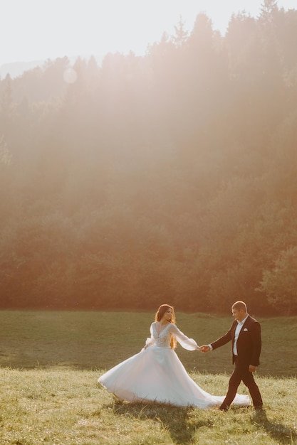 Amantes novios besándose en las montañas al atardecer. retrato, de, novia y novio