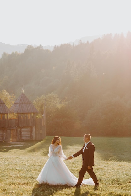 Amantes novios besándose en las montañas al atardecer. retrato, de, novia y novio