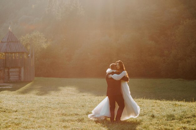 Amantes novios besándose en las montañas al atardecer. retrato, de, novia y novio