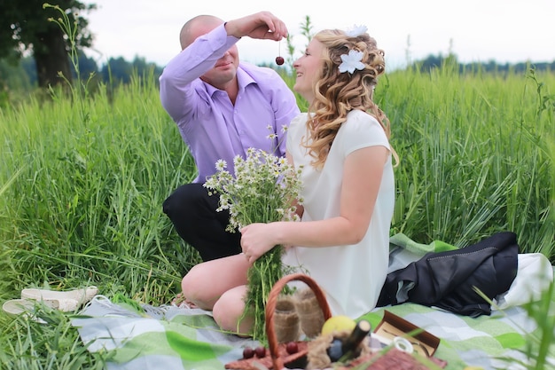 Amantes de la pareja caminando en un campo verde en verano