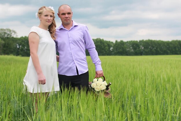 Amantes de la pareja caminando en un campo verde en verano