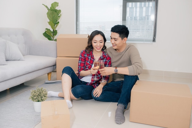 Amantes de la pareja celebrando mudarse a casa nueva con champán