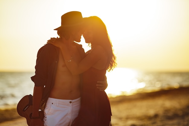 Foto los amantes de la pareja de enamorados abrazándose en la fecha en la playa