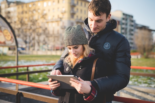 amantes de la pareja joven auténtico usando tableta