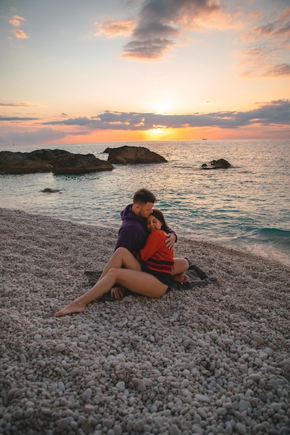 Los amantes de la pareja en la playa disfrutando del tiempo juntos y la puesta de sol sobre el mar Grecia vacaciones en la isla de Lefkada