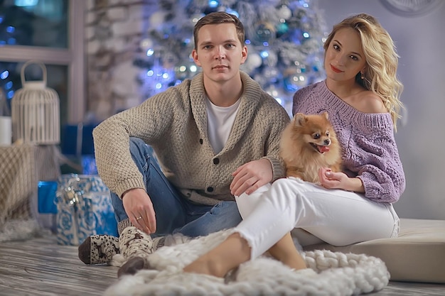 amantes del perro pequeño interior de Año Nuevo / niño y niña abrazan la noche de Navidad, linda familia de perros