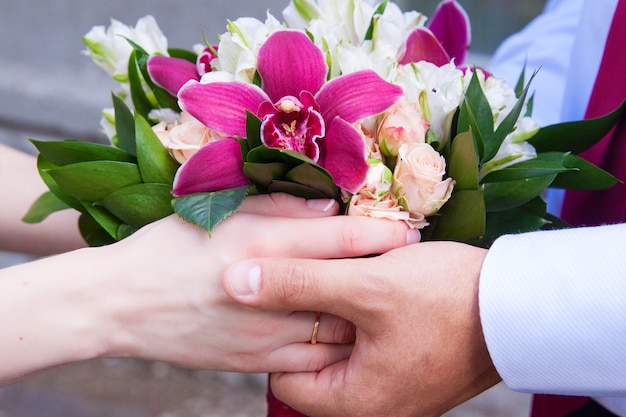 Amantes con un ramo de rosas y orquídeas