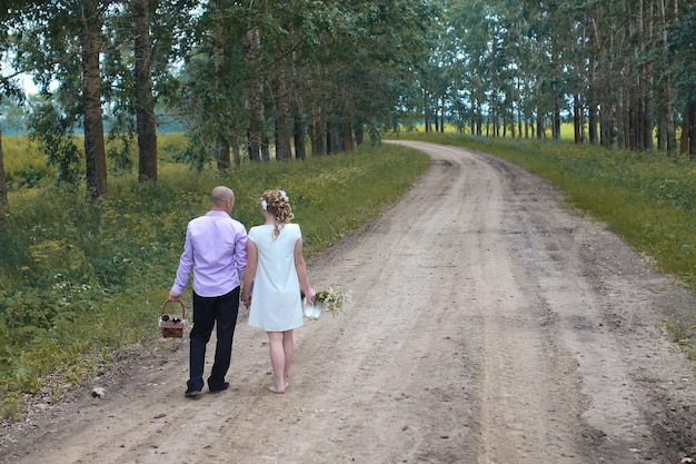 Amantes recién casados caminando en un campo en día de otoño