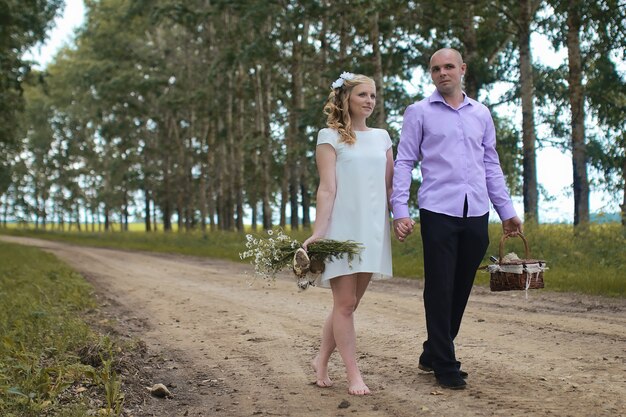 Amantes recién casados caminando en un campo en día de otoño