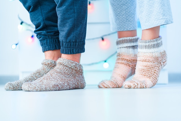 Amantes românticos casal de família em meias quentes de malha macias e aconchegantes no inverno em casa