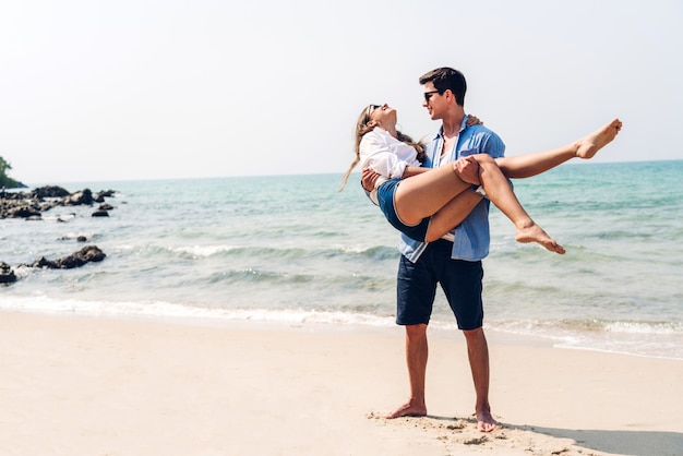 Amantes românticos jovem casal relaxante juntos na praia tropical. Homem abraçando com mulher e aproveitar a vida. Férias de verão