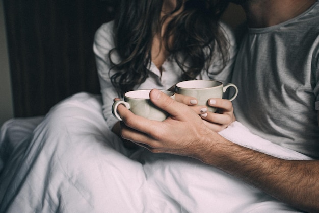 Foto amantes sosteniendo juntos una taza de té