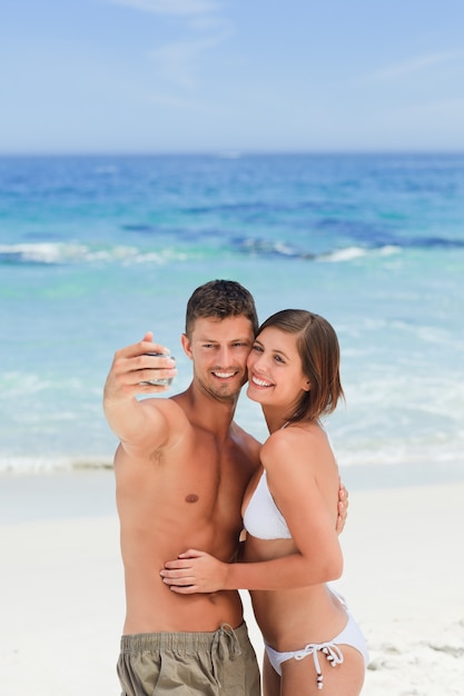 Amantes con su cámara en la playa