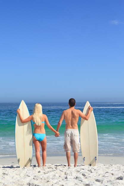 Amantes con sus tablas de surf