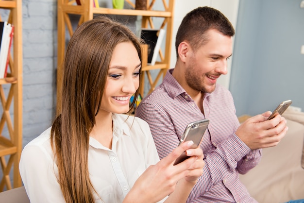 Foto amantes con teléfonos móviles escribiendo mensajes