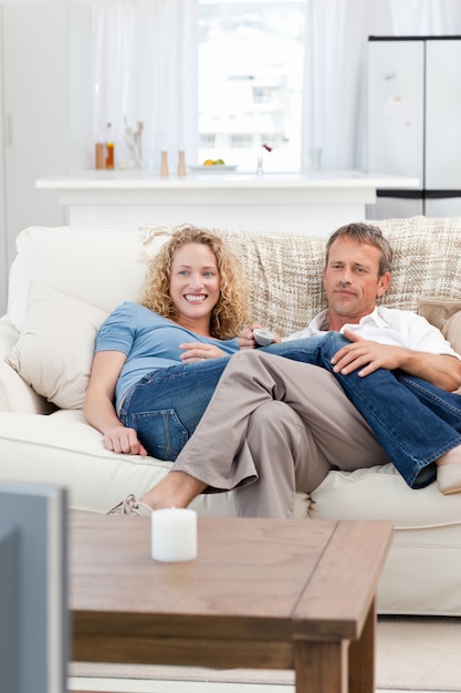 Amantes viendo la televisión en la sala de estar en casa