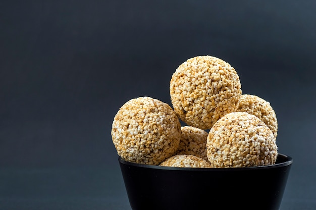 Foto amaranto o rajgira laddu, cholai ke laddo en tazón negro sobre negro