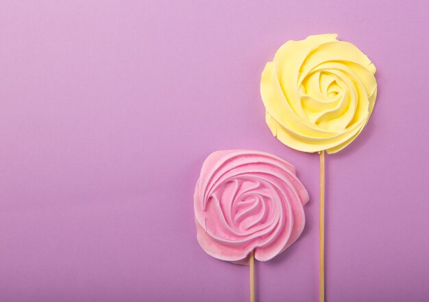 Amarelo e rosa doce de rosa em tons pastel, em uma vara de madeira sobre um fundo cinza, dia dos namorados, dia das mães.