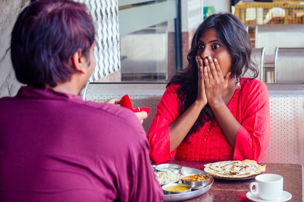 Amasada y sorprendida mujer india sintiéndose feliz de recibir una propuesta de su novio en el restaurante dije que sí