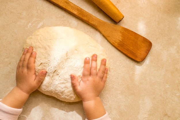 Amasar la masa a mano en la tabla de cortar para la panadería casera