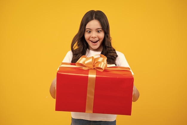 Amazed Teenager Emotionales Teenager-Kind hält Geschenk zum Geburtstag Lustiges Kind, das Geschenkboxen hält, die frohes neues Jahr oder Weihnachten feiern Aufgeregtes Teenager-Mädchen