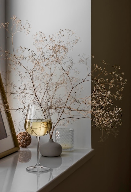 Ambiente acogedor una copa de vino blanco en el alféizar de la ventana en un interior escandinavo