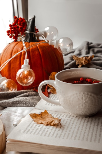 ambiente acogedor de otoño y té caliente en una taza blanca