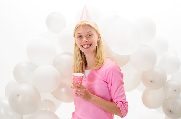 Ambiente de fiesta. Hermosa chica con sombrero de cumpleaños con globos. Feliz cumpleaños.