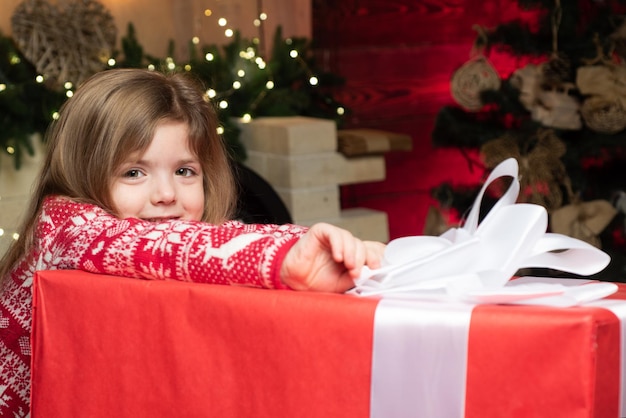 Ambiente navideño acogedor. Nochebuena de niña bebé. Feliz navidad y próspero año nuevo. La niña linda del niño juega cerca del árbol de navidad. Los niños disfrutan de las vacaciones de invierno en casa. Hogar lleno de alegría y amor