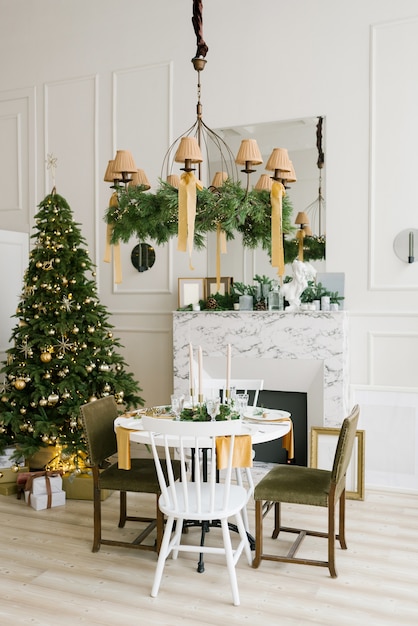 Ambiente navideño y confort en el salón. Mesa festiva junto a la chimenea de mármol.