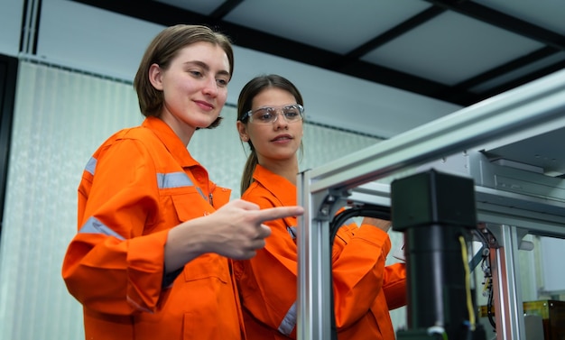 Ambos de una mujer en una fábrica de piezas electrónicas usando un controlador de línea de producción