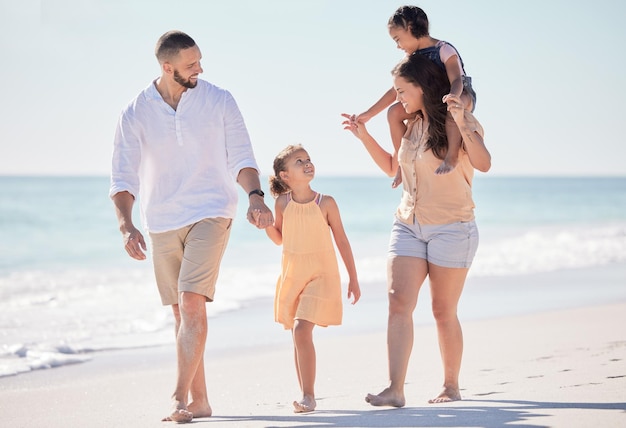 Ame feliz e a família ande na praia divirta-se e aproveite o tempo de qualidade juntos na água, mar ou oceano Família feliz de mãe, pai e filhos viajam na areia para paz, liberdade ou bem-estar