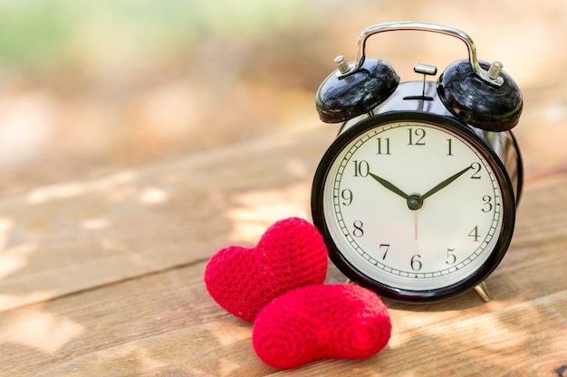 Ame el reloj con el corazón en los tiempos de mañana de la tabla de madera