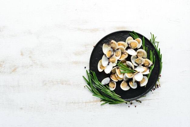 Amêijoas cozidas em um prato de frutos do mar em um fundo branco