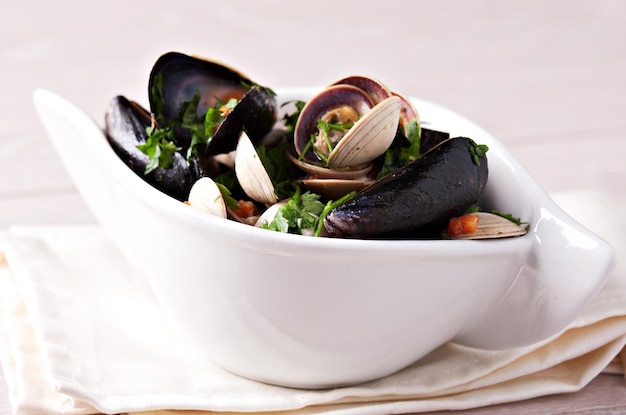 Amêijoas de frutos do mar Vongole com tomate e salsa em uma tigela