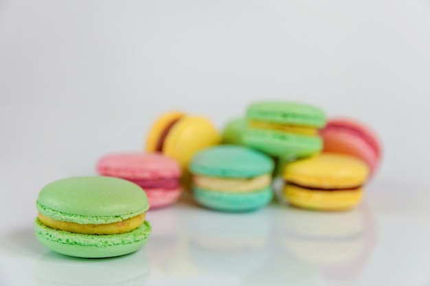 Amêndoa doce colorida rosa azul amarelo verde macaron ou bolo de sobremesa macaroon isolado nas costas brancas ...