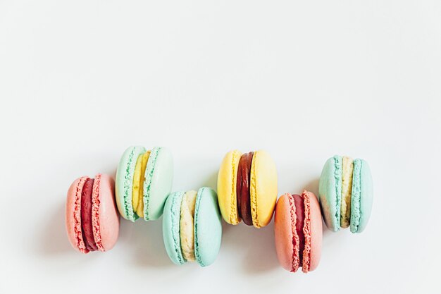 Amêndoa doce colorido rosa pastel azul amarelo verde macaron ou bolo de sobremesa macaroon isolado no branco