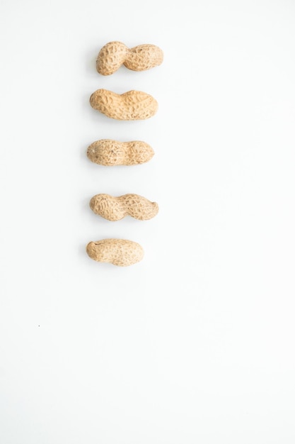 Amendoins secos em closeup de casca isolados no fundo branco