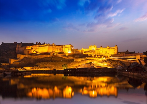 Amer Fort Amber Fort iluminado à noite uma das principais atrações em Jaipur Rajastan Índia refletindo no lago Maota no crepúsculo