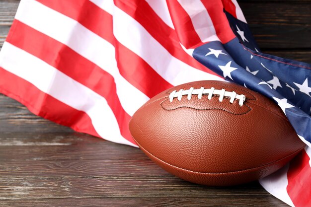 Foto american football ball und amerikanische flagge auf holzuntergrund