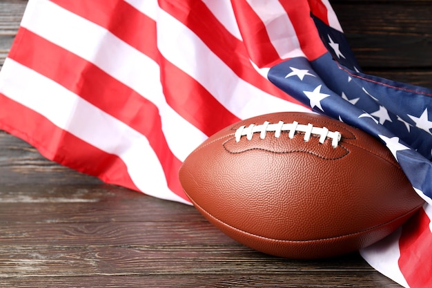 Foto american football ball und amerikanische flagge auf holzuntergrund