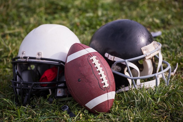 American-football-helme und ball liegen auf dem feld