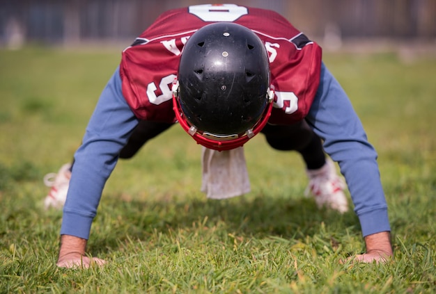 American-Football-Spieler macht Liegestütze während des Trainings auf dem Feld