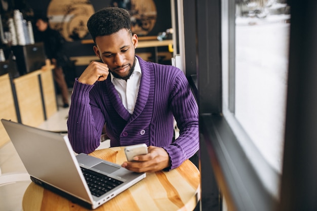 Americano africano com telefone em um café