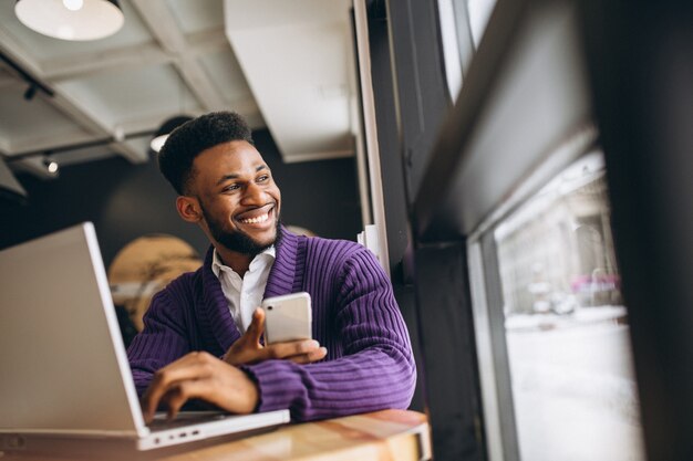 Americano africano com telefone em um café