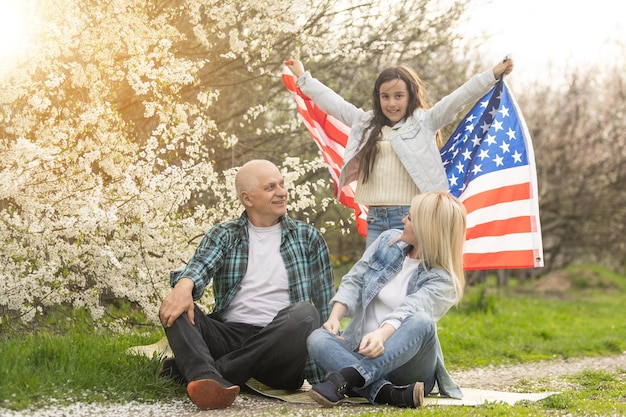 Amerikanische Familie mit USA-Flagge im Freien.