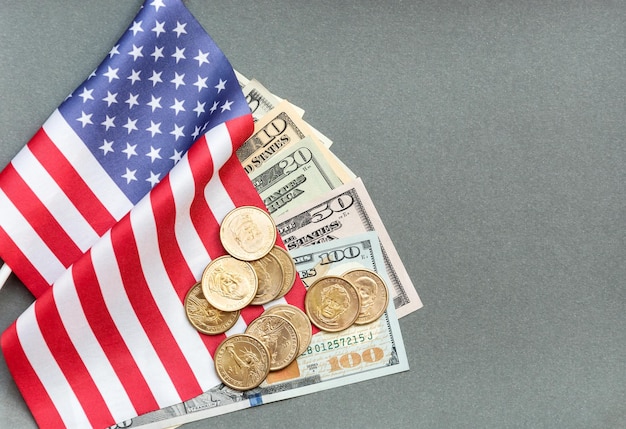 Amerikanische Flagge mit amerikanischem Geld auf dem grauen Hintergrund