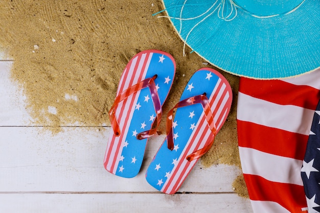 Amerikanische Flagge Sommerferien mit Zubehör auf Flip Flops Holz Hintergrund