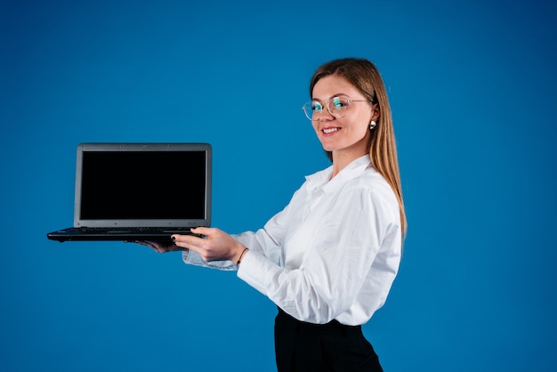 Amerikanische Geschäftsfrau, die einen Laptop hält, lokalisiert auf blauem Hintergrund