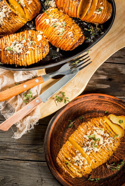 Amerikanische traditionelle Hausmannskost. Die vegane Ernährung. Selbst gemachte Hasselback-Kartoffel mit frischen Kräutern und Käse.